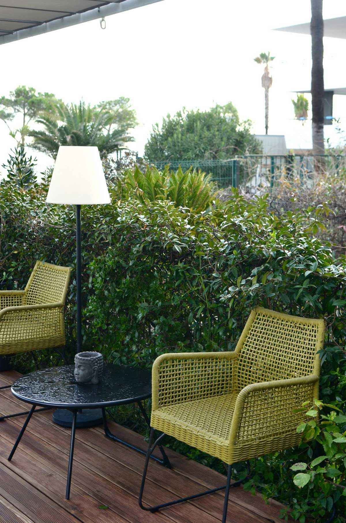 Aménagement d’une terrasse en bois avec mobilier en rotin et éclairage extérieur – Création d’un espace détente par AK Rénovation dans le Pays de Gex